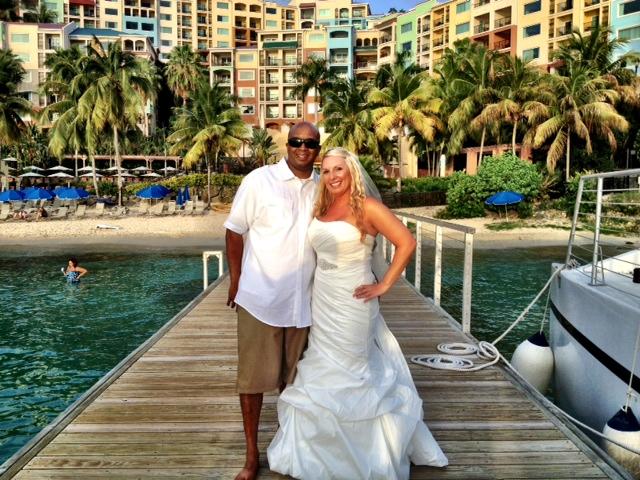 Couple on a dock, tropical resort background, palm trees, woman in wedding dress, waterfront view.