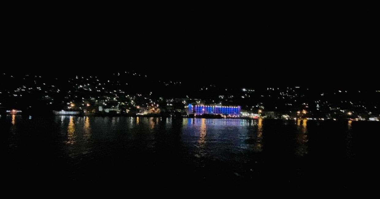 Night view of city lights reflecting on calm water.
